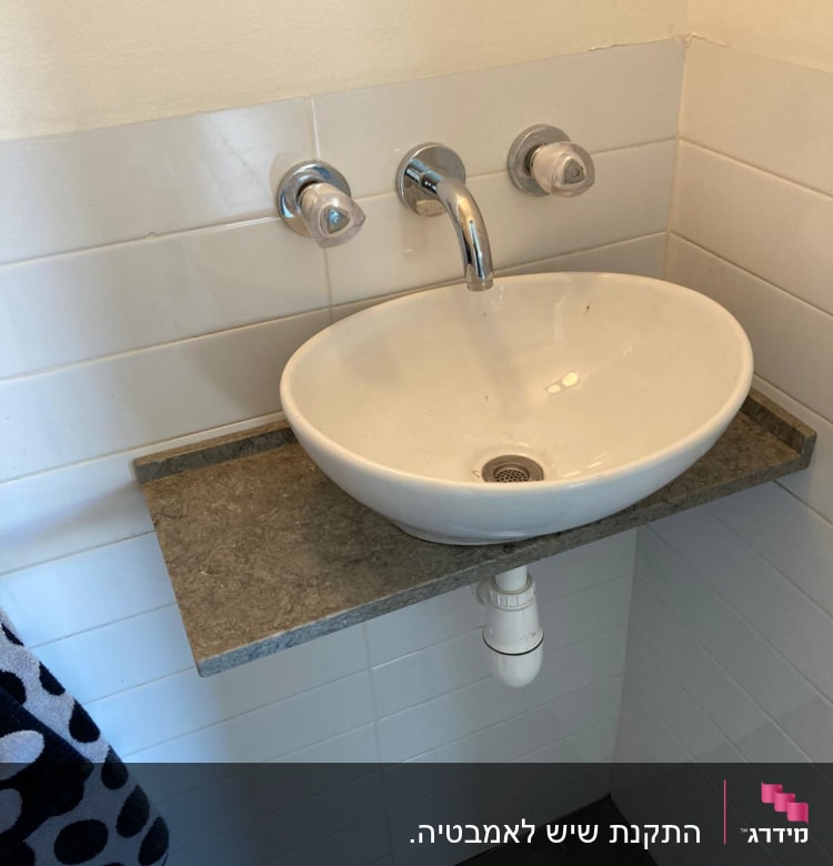 כיור על משטח שיש אפור עם ברז כרום